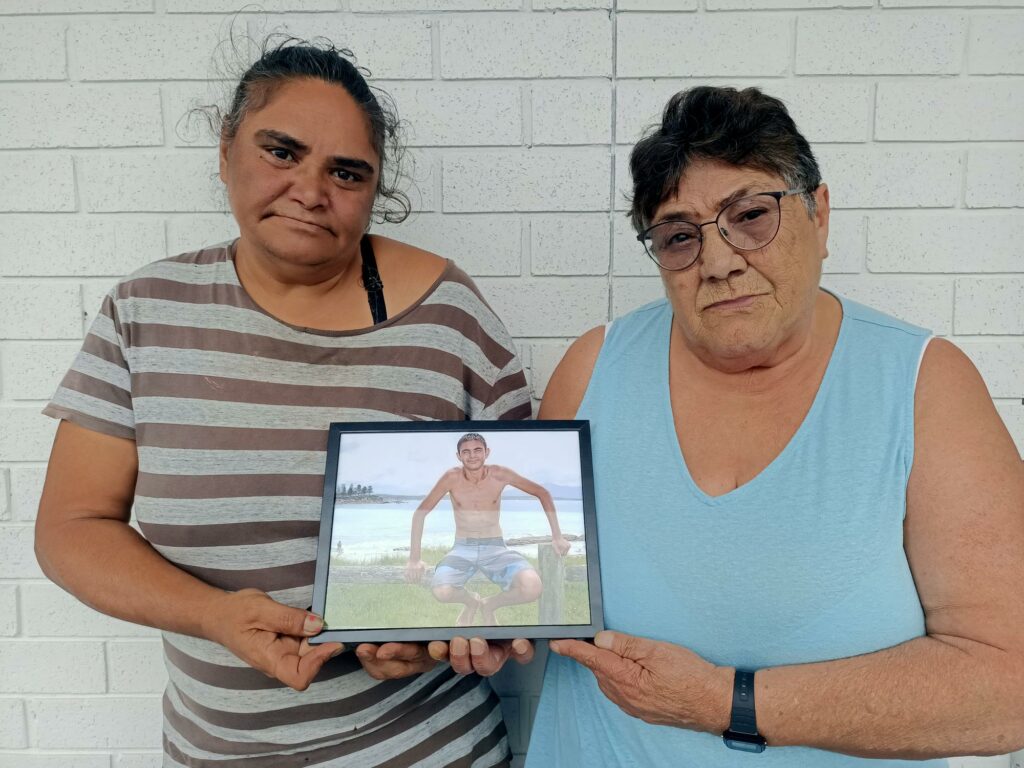 Karen Campbell (L) and Fay Campbell (R) stand with a picture of George before the coronial inquest examining possible issues in DCJ care of George Campbell