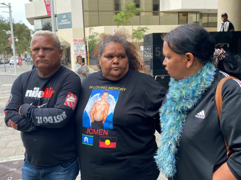 Three Blanket family members, one wearing a t-shirt with the words 'in loving memory of jomen'