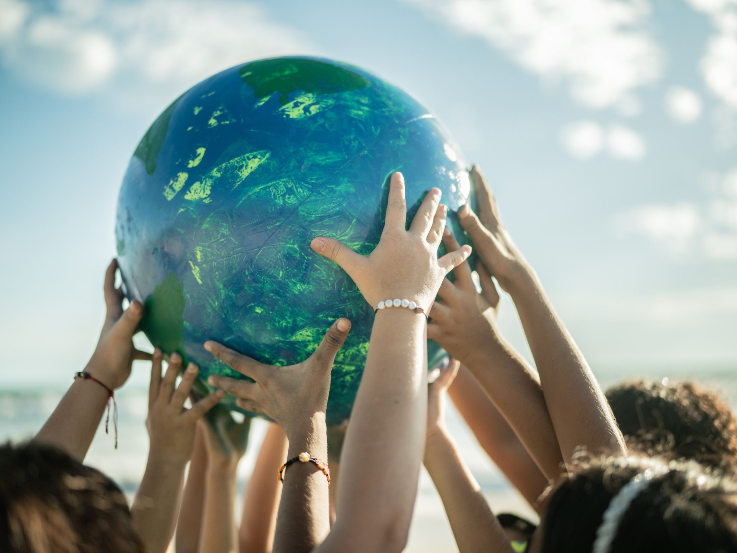 Children's hands holding a globe