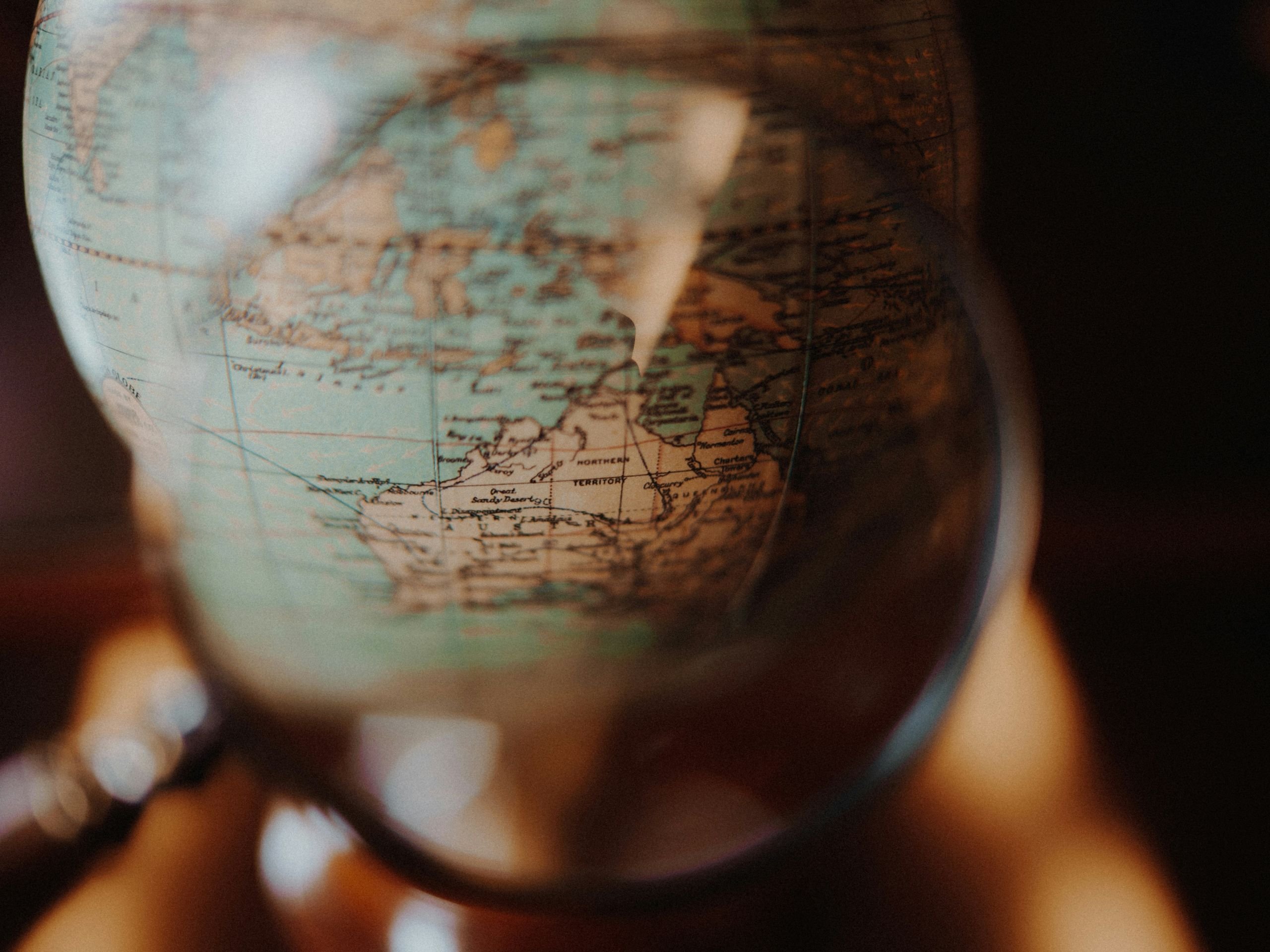 Map of Australia under a magnifying glass over a globe