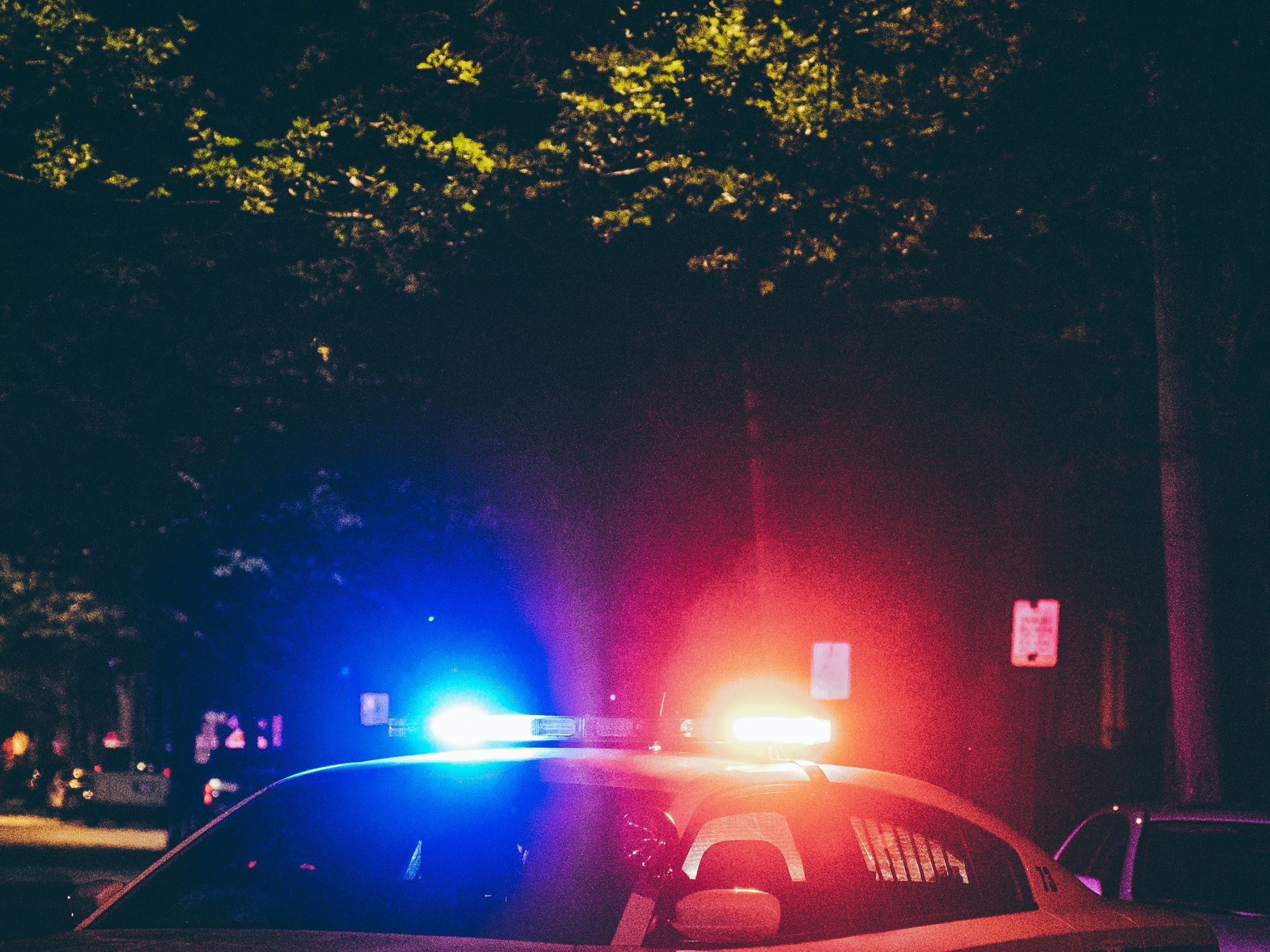 Red and blue lights on top of police car at night